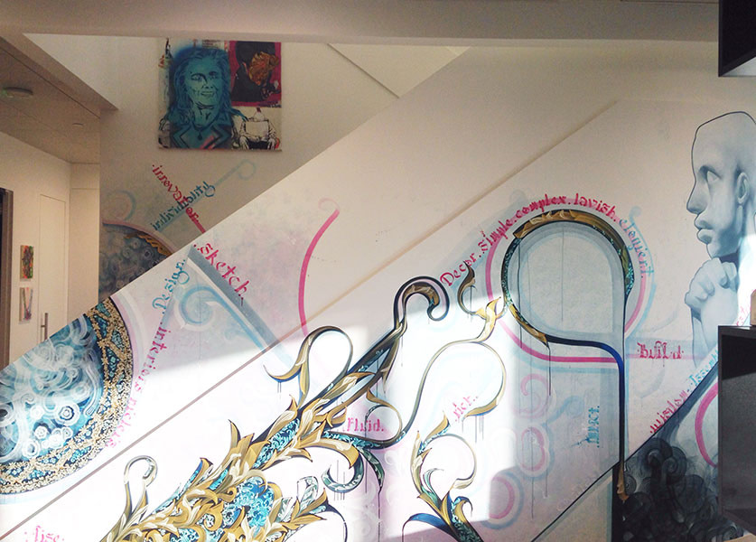 A piece by Eddie Streets hangs above a mural by Aise Born in IA's LA office. Photo by Sara Laurence.