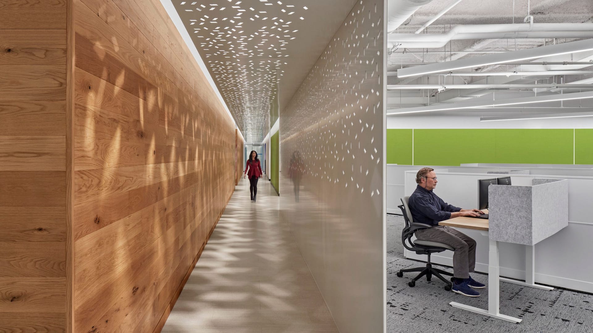 A hallway with perforated partitions at the Verisk Boston offices.