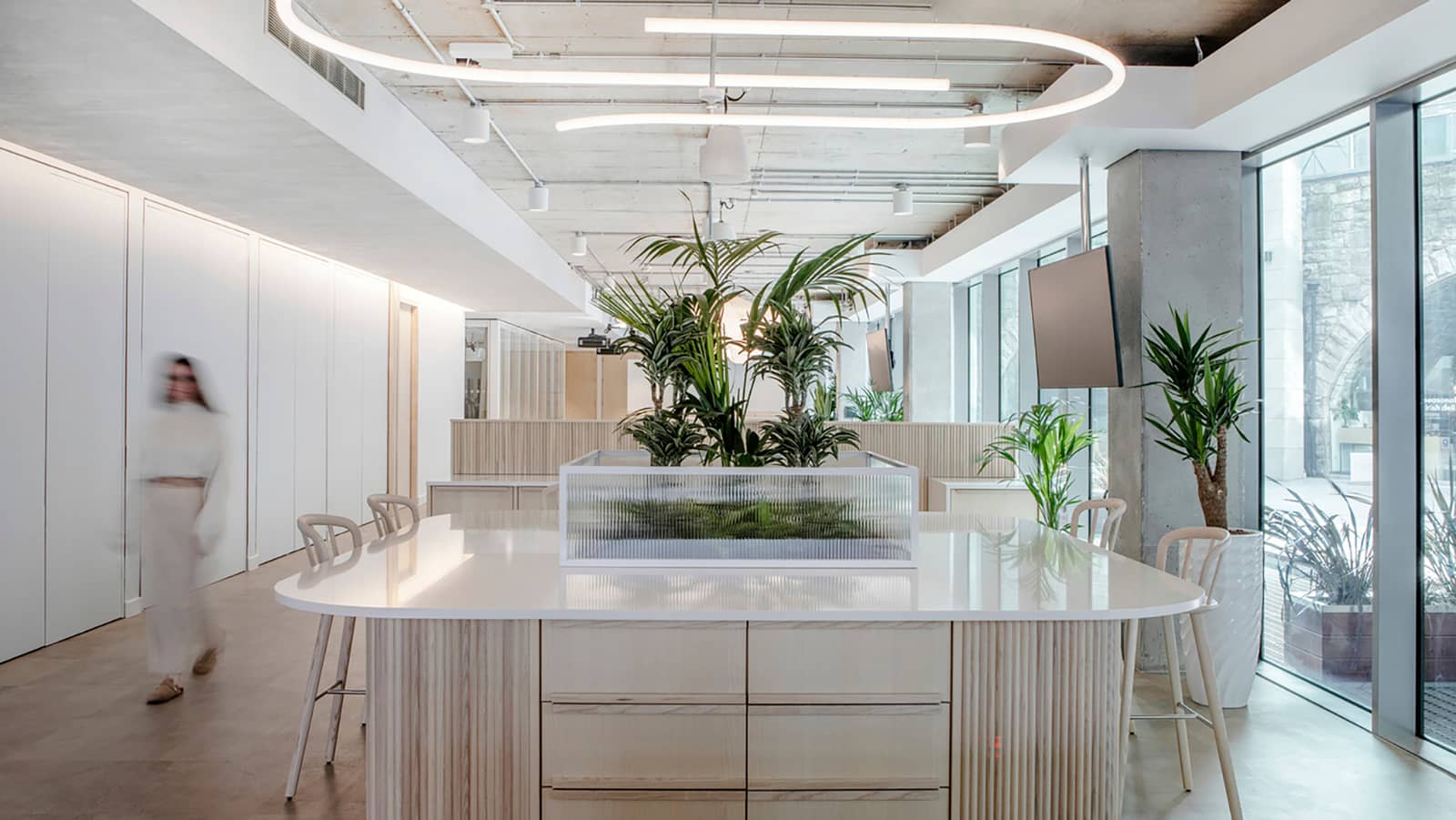 The Dropbox Dublin headquarters features a large worktop space with lightwood finishes, topped with granite and a biophilic display.