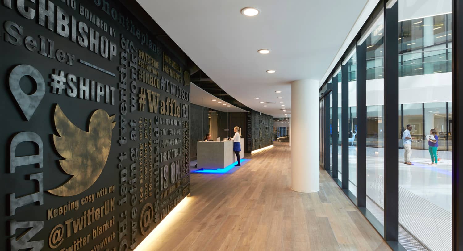 Wall with Twitter bird logo, reception desk beyond.
